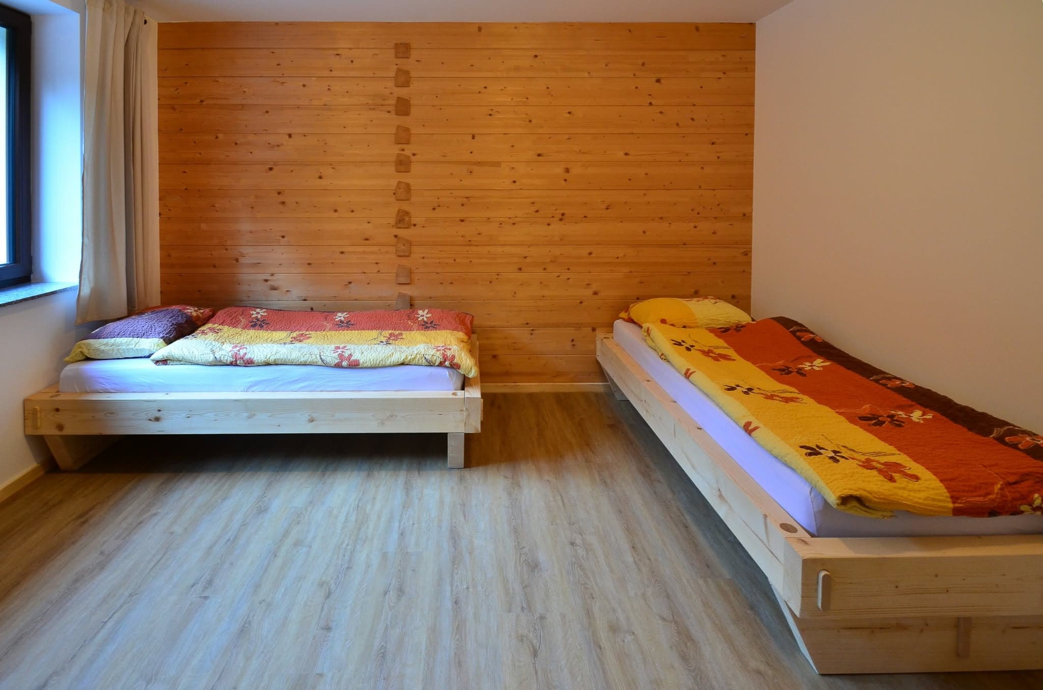 Soba z lesenimi stenami in dvema posteljama